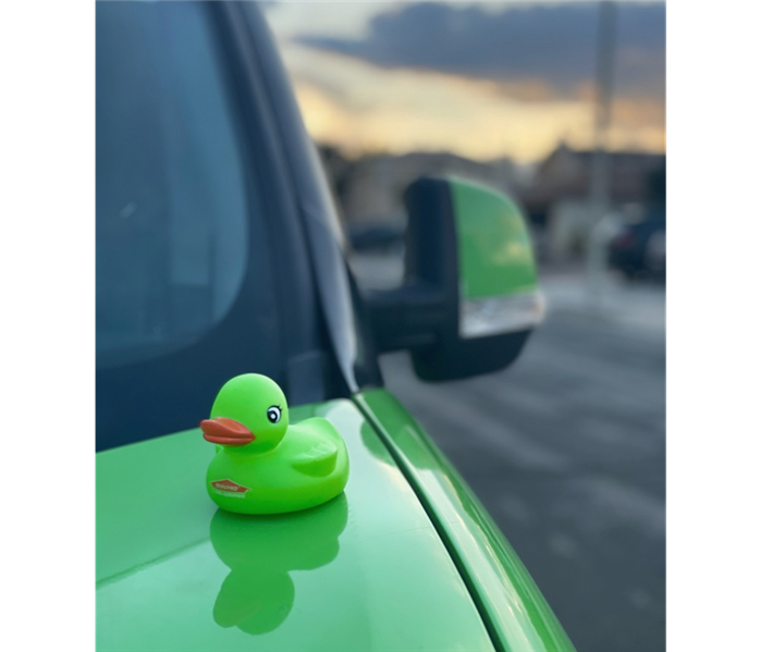Green rubber duck sitting on top of a SERVPRO Van 